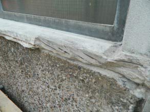 Betonfensterbank mit abgeplatzten Stellen